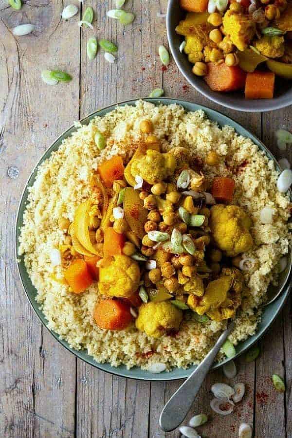 Overhead view of North African food including cauliflower, carrots and chickpeas. Spoon on the side.