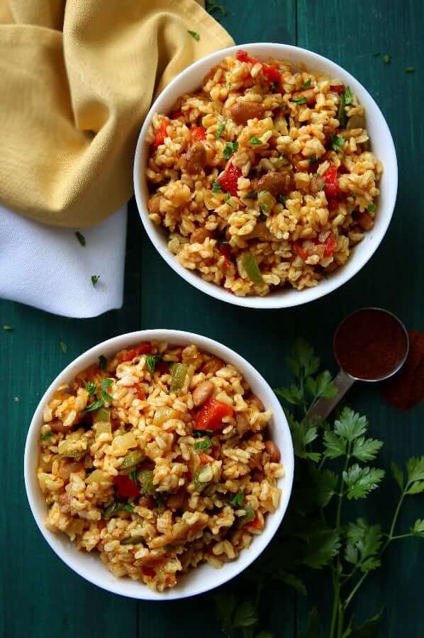 Overhead photo of two bowls of colorful Spanish rice with beans.