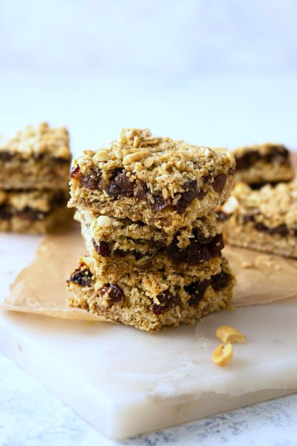 Front view of Oatmeal Raisin Bars that are in a stack of three with more bars behind.