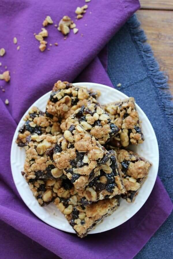 Overhead view of a stack of jam filled crumb bars set against purple and blue.