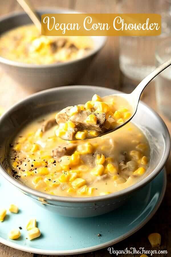 Close-up photo of a spoonful of corn chowder with chunks of meatless sausage and fresh corn kernels.