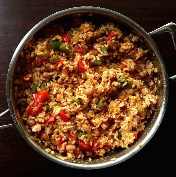 Overhead photo of the complete meal of Spanish Rice and Beans in colors of red and golds.