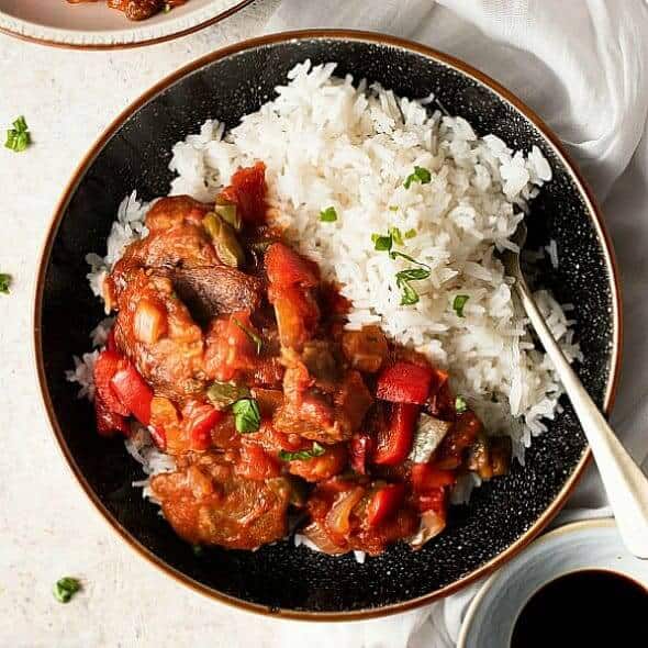 Overhead view of a fork full of pepper steak mixture served over rice.