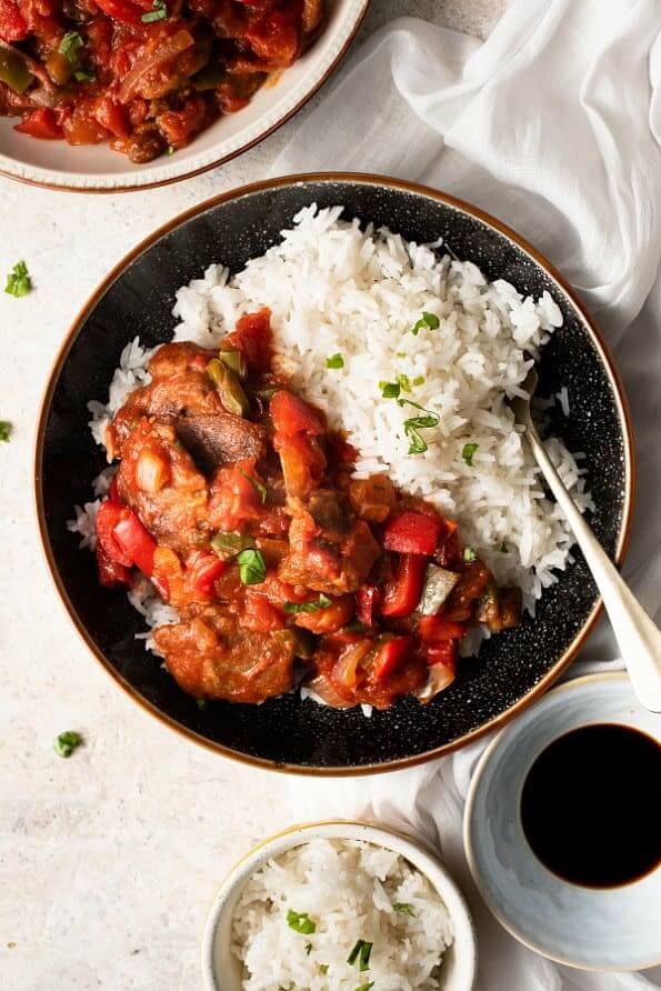 Overhead photo of a plateful of pepper steak next to rice.