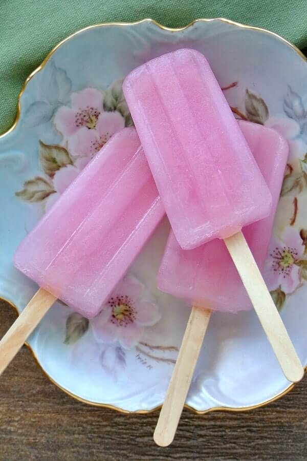 Three deep pink frozen treats on an antique flowered plate.