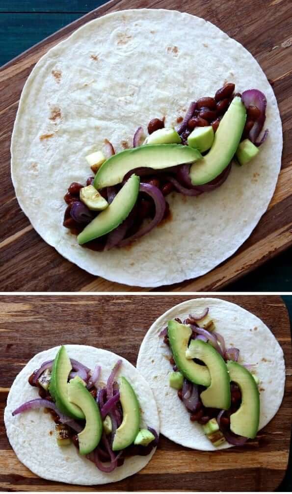 Overhead view of two different sized tortillas being filled with burrito vegetables.