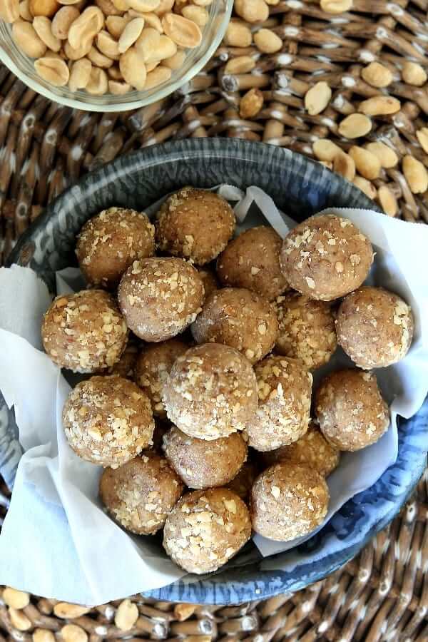 Overhead photo of a gray enamelware bowl lined with parchment and filled with protein peanut butter balls.