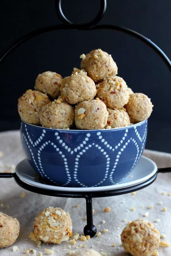 Close up photo os peanut butter energy balls spilling out of a blue and white bowl.