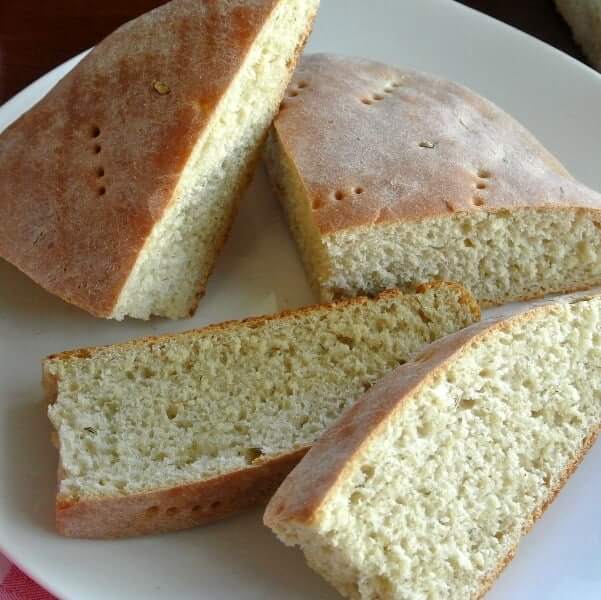 A slab of homemade bread with slices on the side.