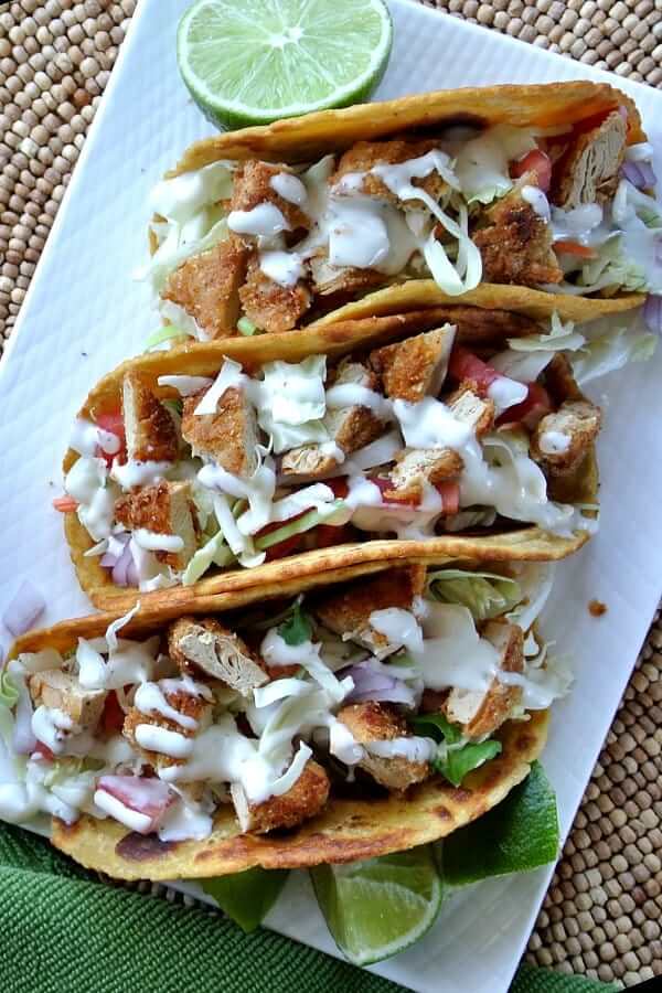 Overhed view of three taco shells filled with vegan chicken and veggies.