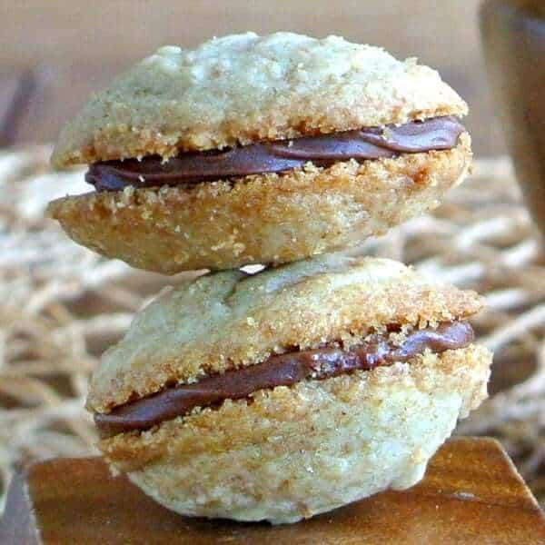 Close up of two chocolate filled cookies in a square photo.