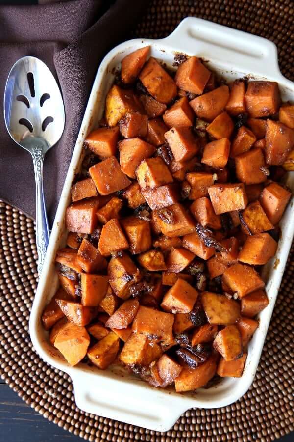 Overhead view of baked sweet potato chunks mixed with pecans and raisins.