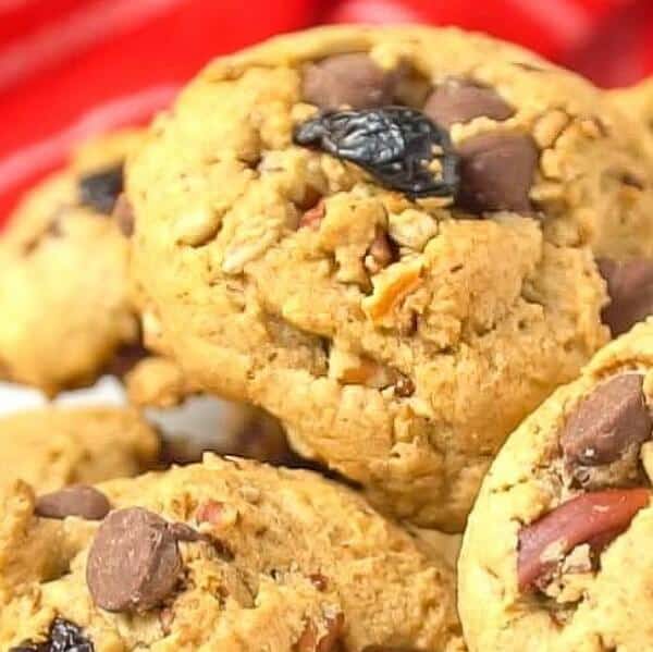 Close up of chocolate chip pecan cookies stacked in a huge pile.