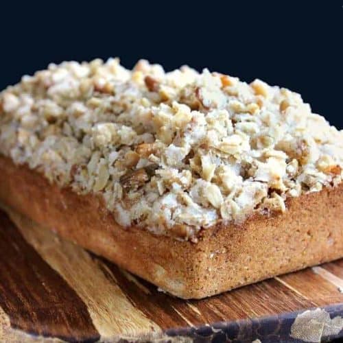 A close up view of aloaf of banana bread covered with a deep layer of cereal streusel topping.