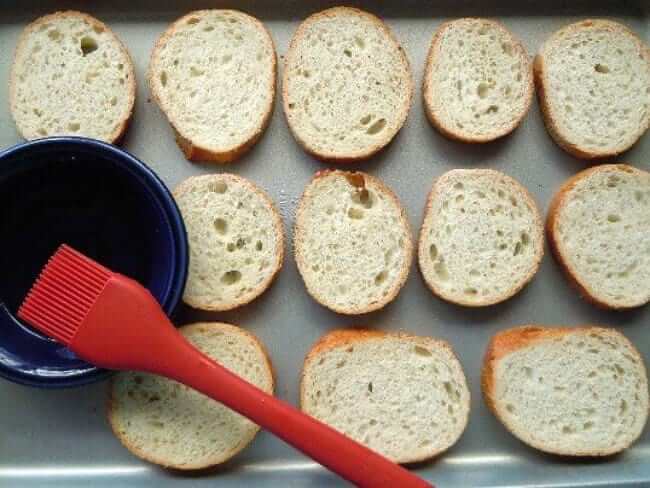 Overhead photo of sliced breads being prepared for broiling.