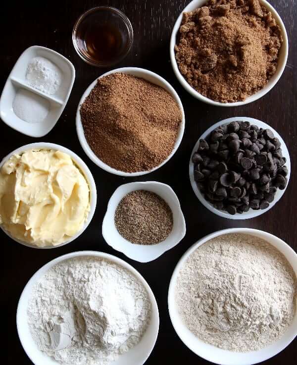 Cookie ingredients in separate white bowls and each with a different shape.