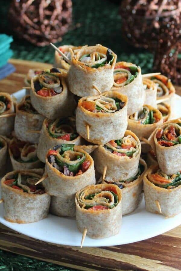Tortilla appetizer rolled up with layers of pesto, spinach and much more. Rolled tight and pierced with a toothpick. One of many Mexican food recipes in this list.