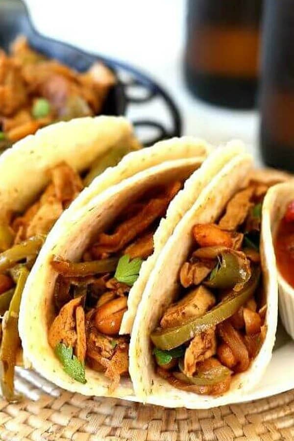 Two taco shells filled with a great variety of sauted veggies and meatless chicken.