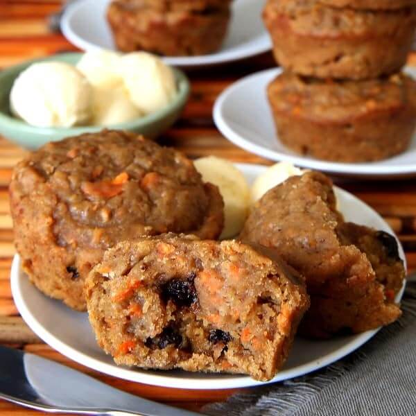 Square photo of an opened quick bread on a white plate with balls of dairy free butter behind.