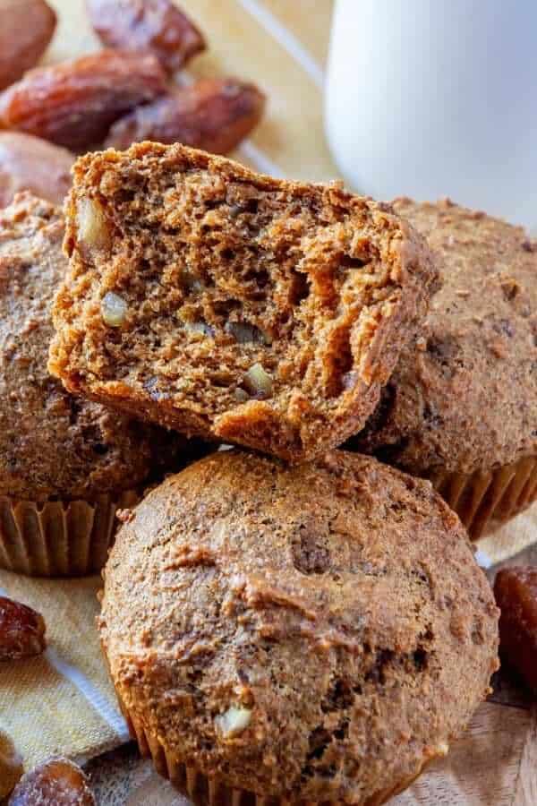 Close-up of an open bran muffin sitting on top of a full muffin.