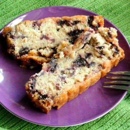 Two slices of a moist cake showing blueberries through the slices.