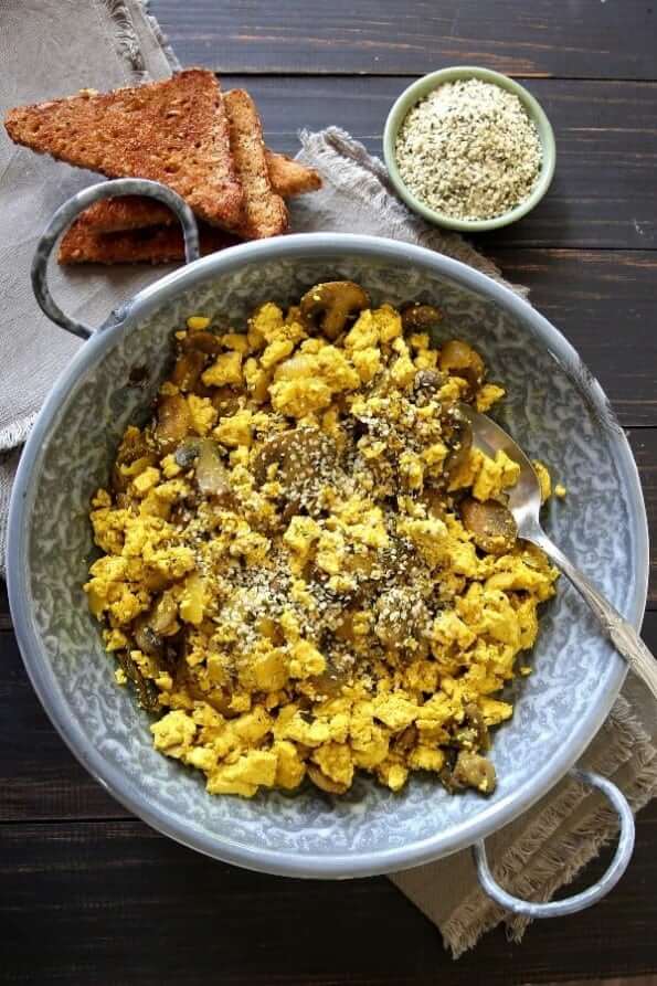 Looking down at a large grey enamelware bowl full of a warm breakfast.