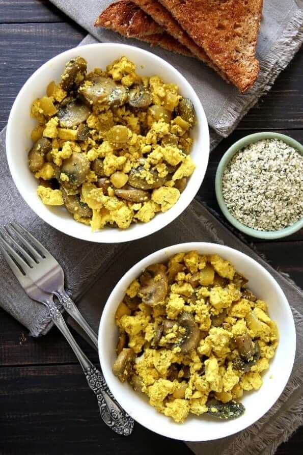 Lookng down at two bowls full of vegan tofu scramble with toast.