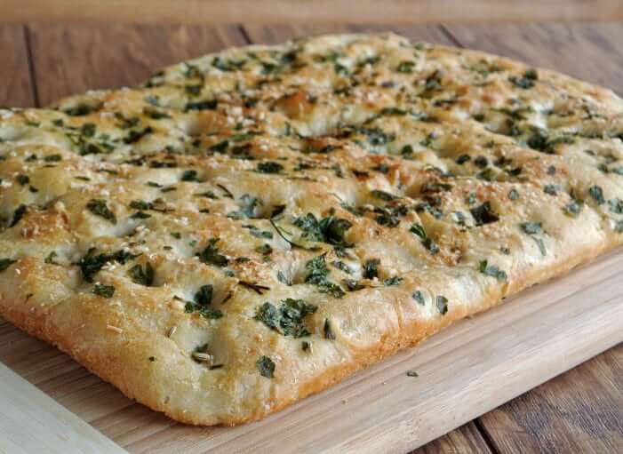 A full load of vegan focaccia bread baked to a golden brown.