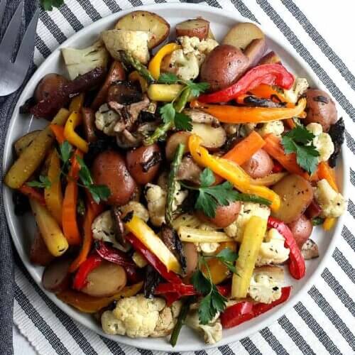 Overhead photo of a colorful plateful of at least 8 vegetables roasted to perfection.