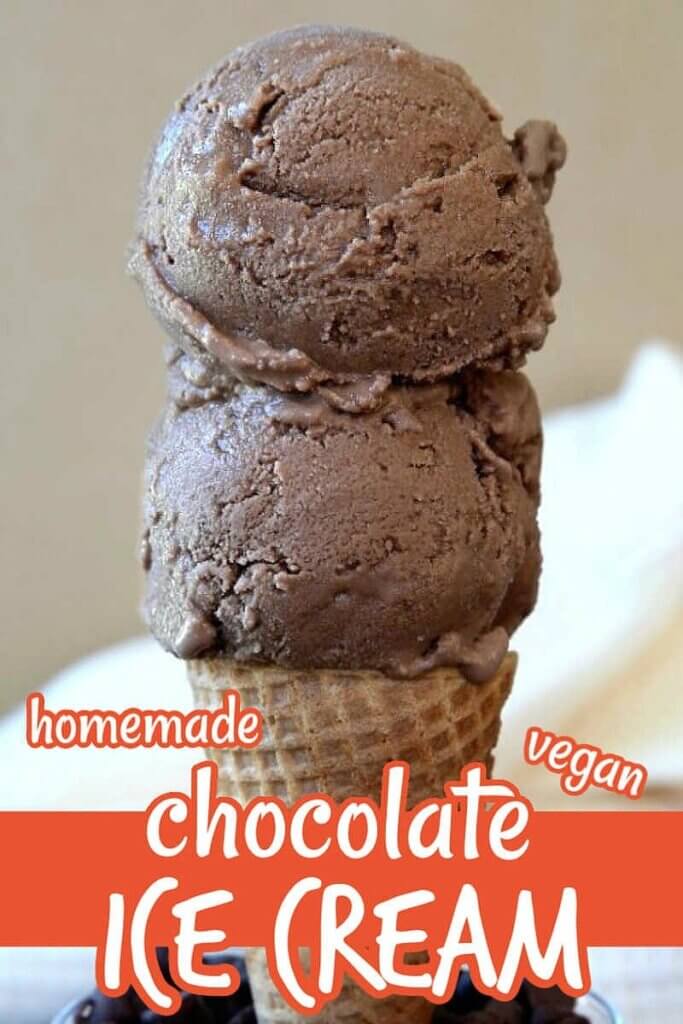 Two scoops of vegan chocolate ice cream on a cone and standing in a glass of chocolate chips.