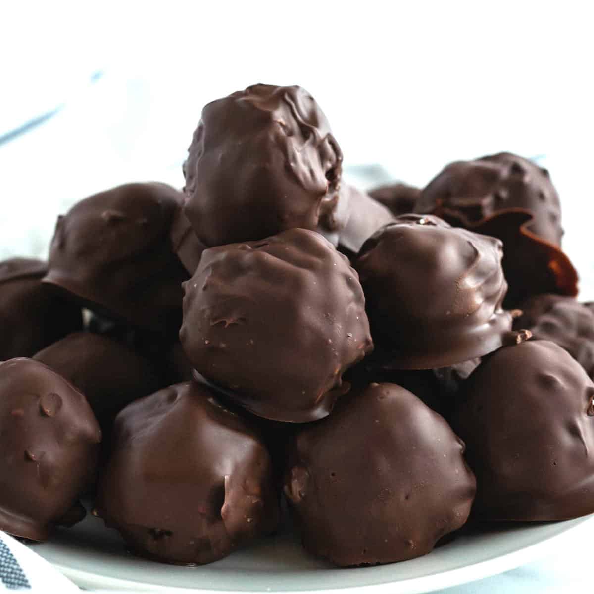 A pile of peanut butter rice krispie balls are on a white plate with white background.