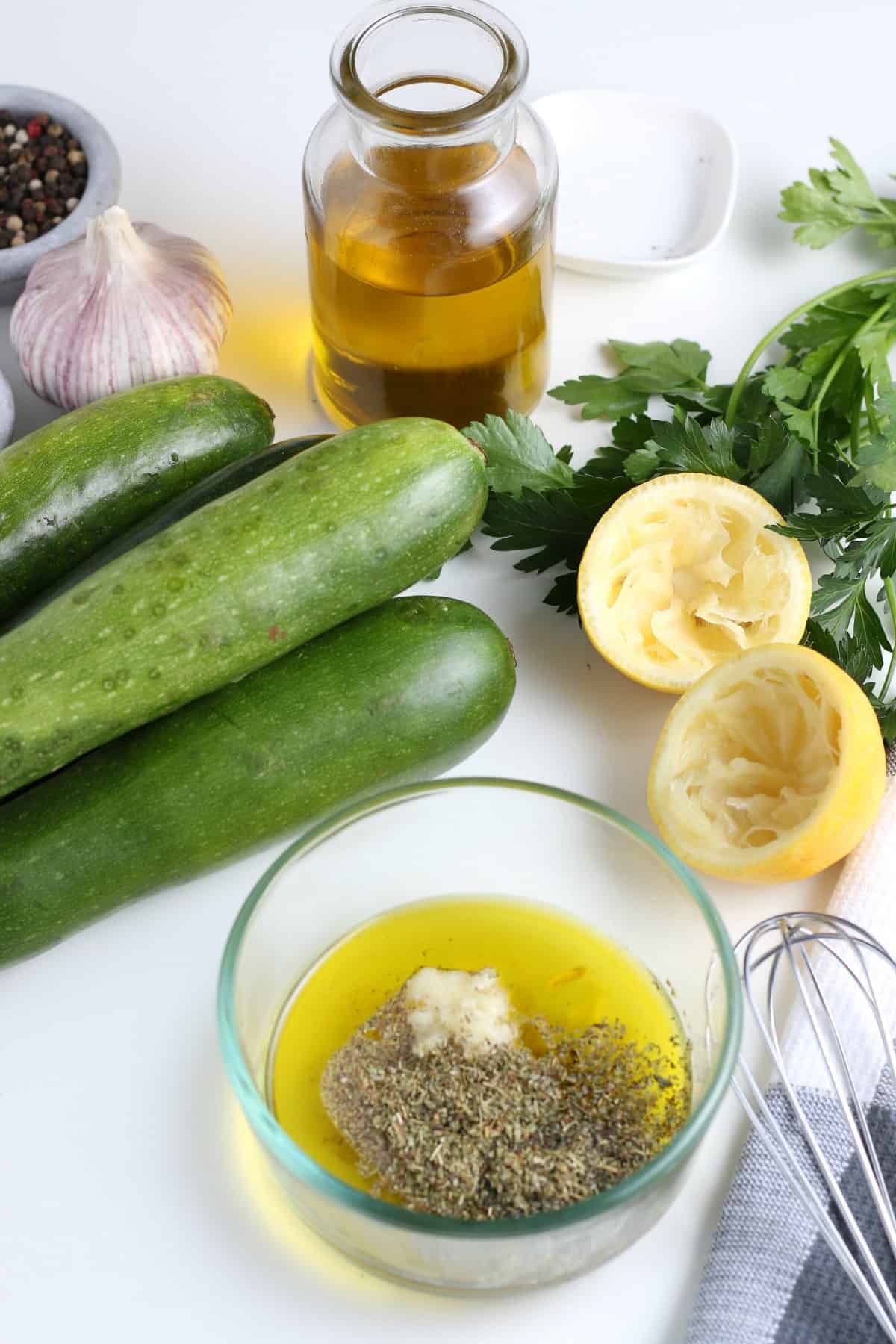 photo showing the ingredients for the marinade in a small bowl waiting to be mixed together with a whisk on the side.