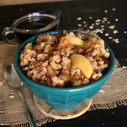 A turquoise bowl is filled with apples and oats.