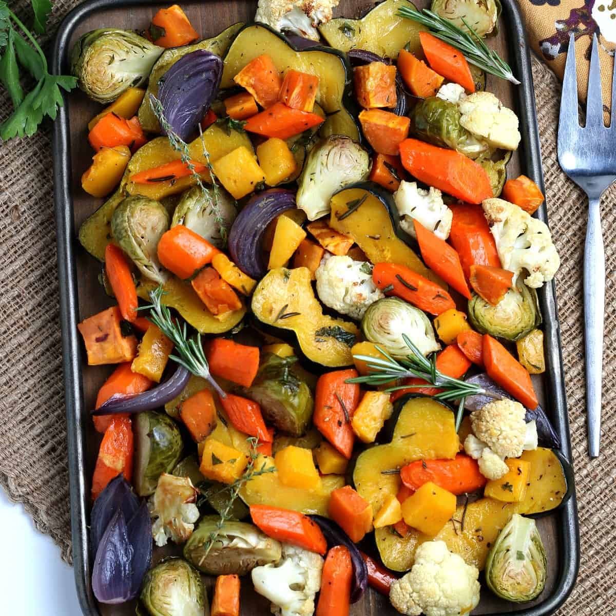 Looking down at a slew of colorful roasted fall vegetables on a tray.