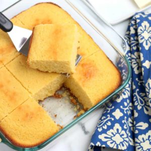 Overhead view of Easy Vegan Cornbread being lifted out of a square baking dish.