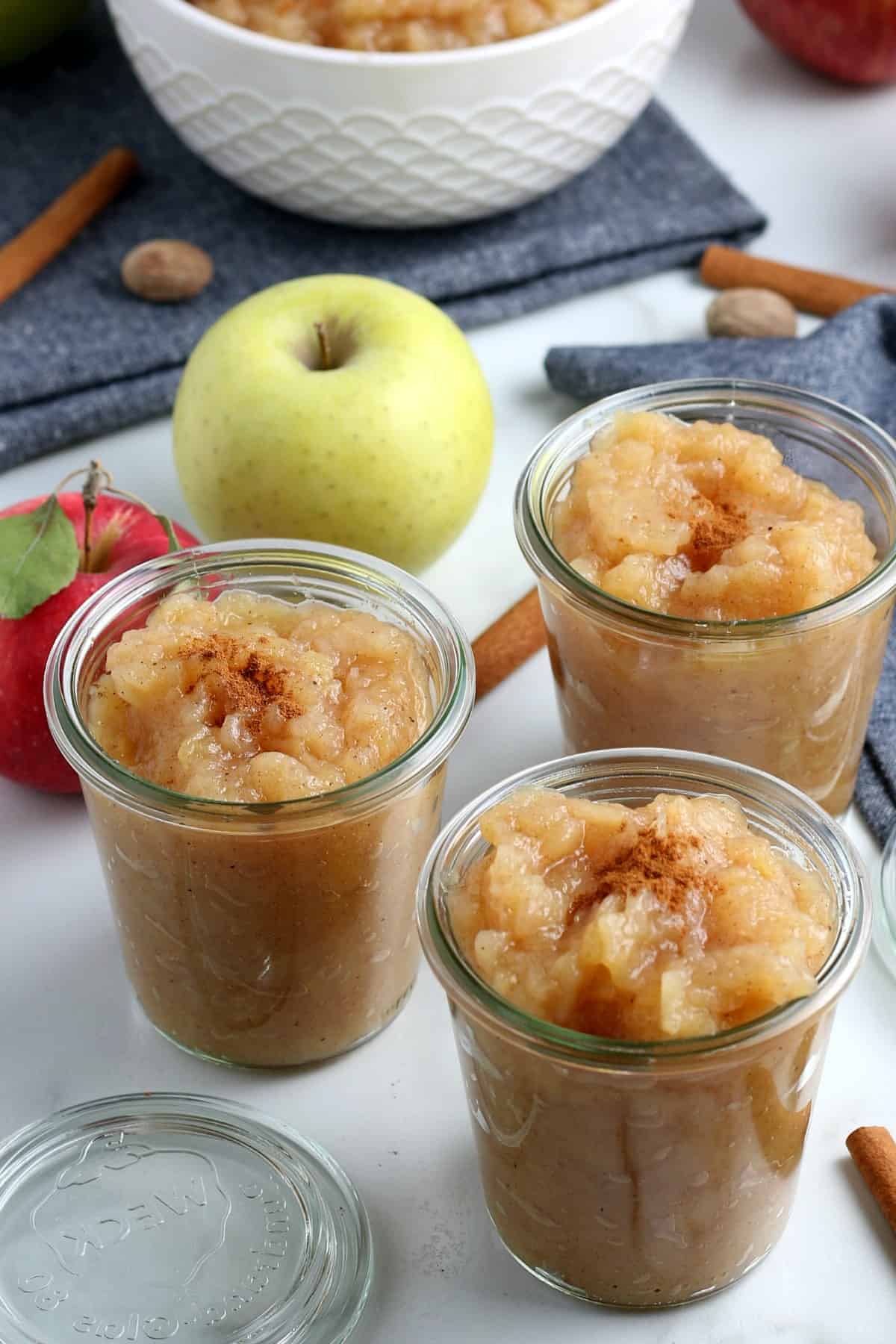 Looking down at three jars of apples made into a sauce.