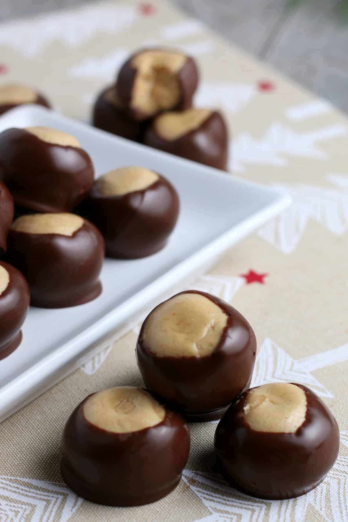 Stack of three dipped chocolate and peanut butter candy balls.