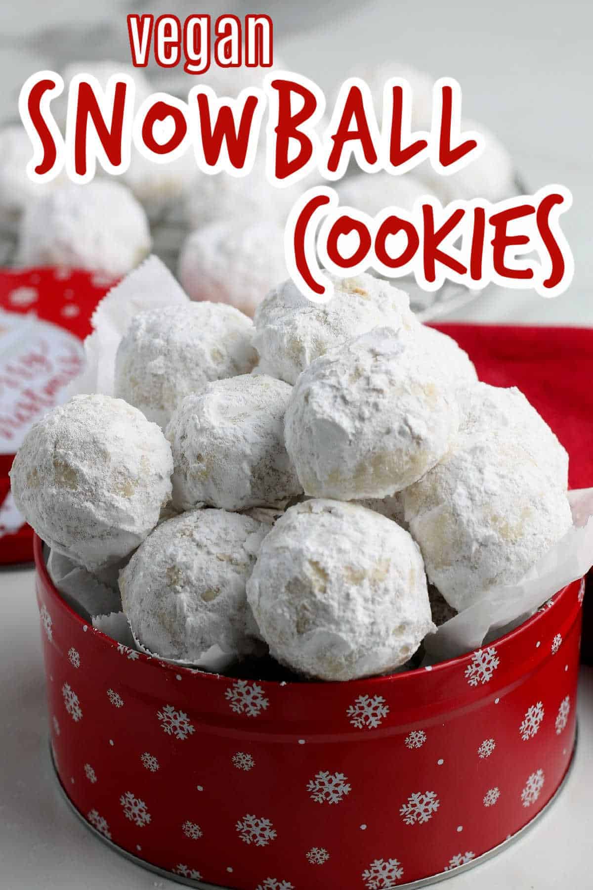 A red tin filled with white snowball cookie Christmas treats.