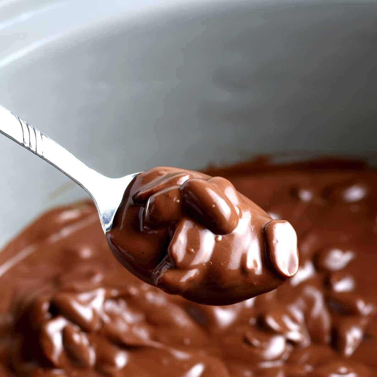 Christmas chocolate is melted with peanuts and scooped up with a tablespoon.