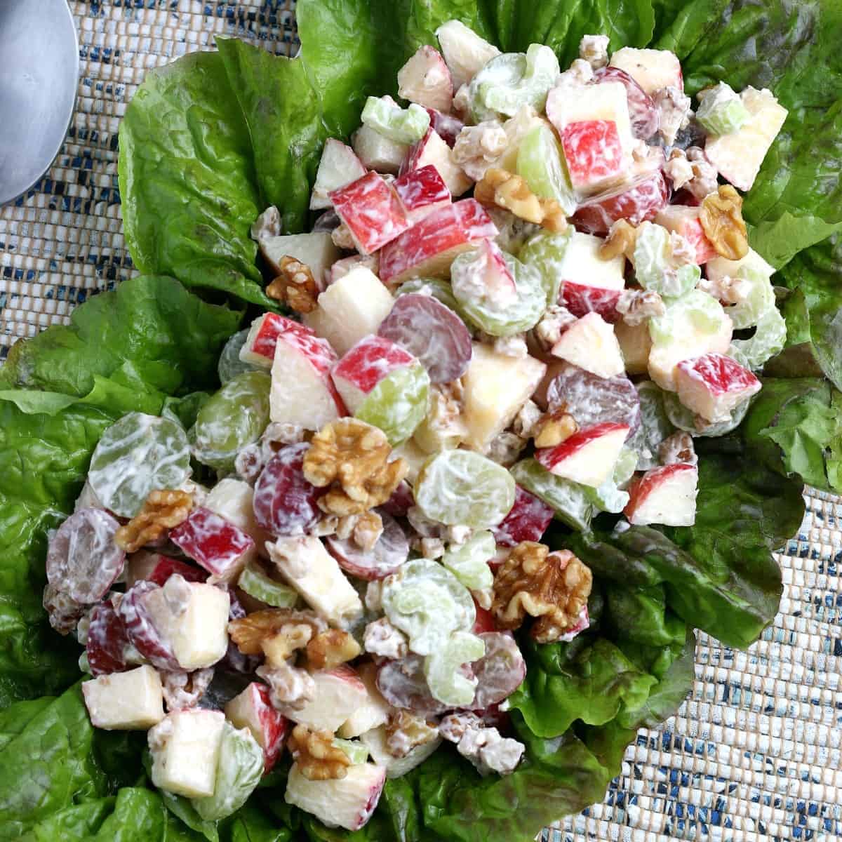 Overhead view of vegan Waldorf Salad on a bed of lettuce.