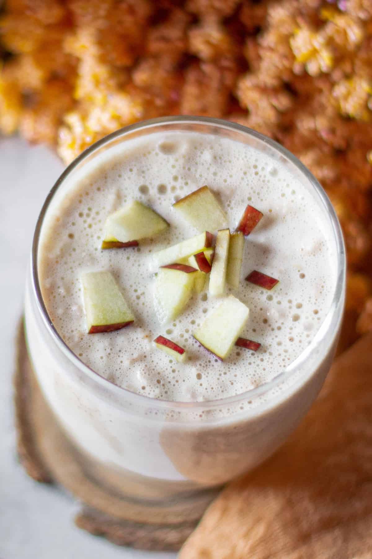 Close up looking down at apple smoothie garnished with apple cubes.