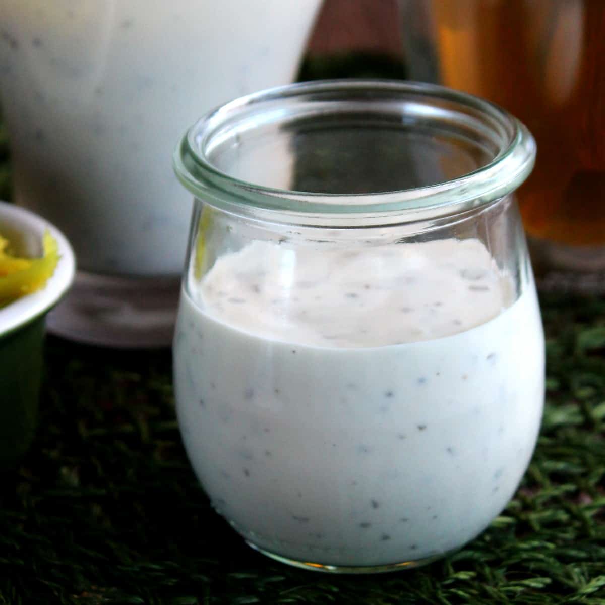 Jarful of dairy free ranch dressing with a jugful behind.