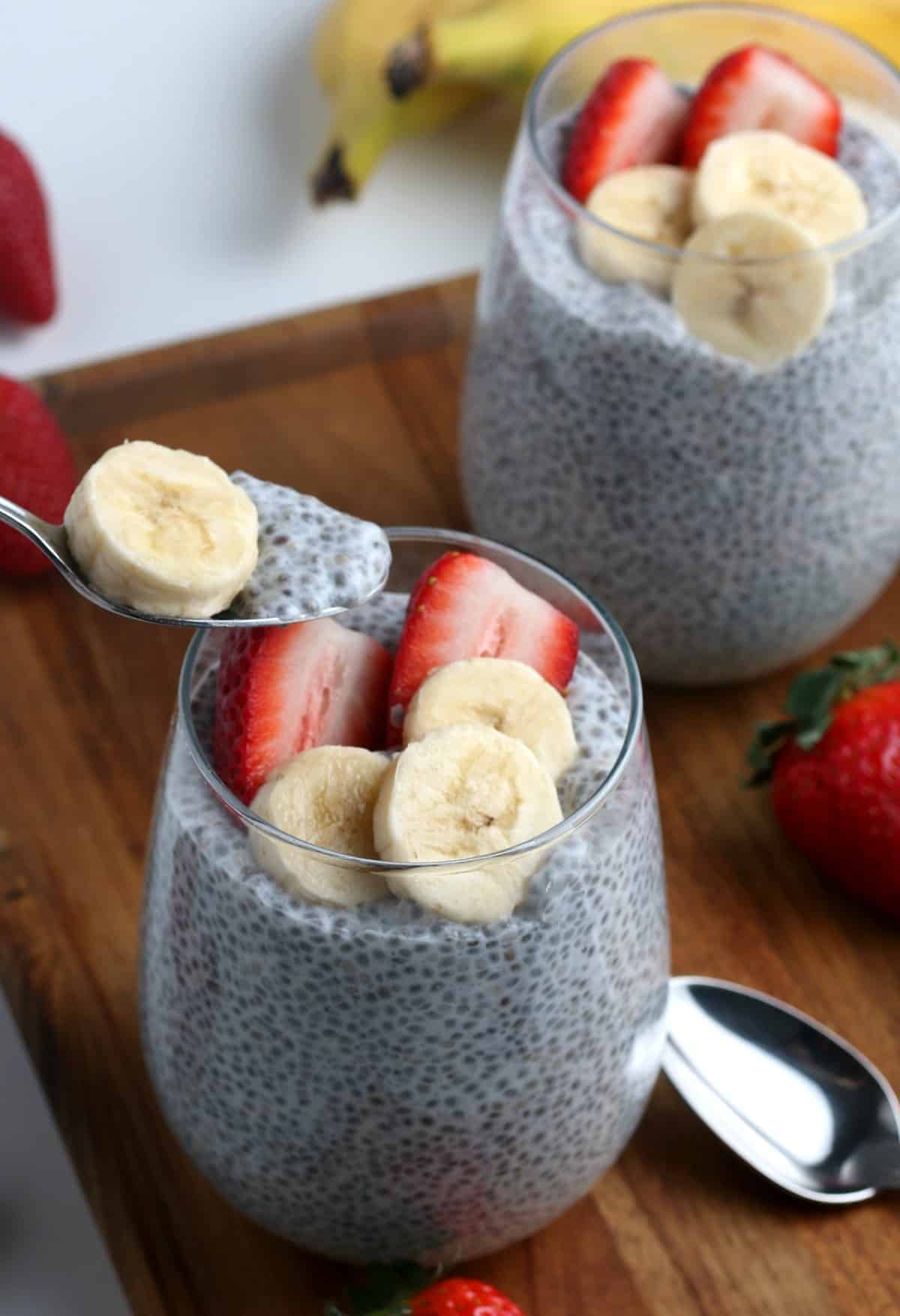 A spoon is dipping out a spoonful of vanilla chia pudding.