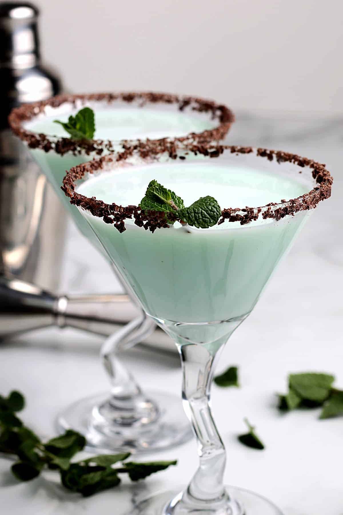 Two martini glasses filled with a minty green cocotail.