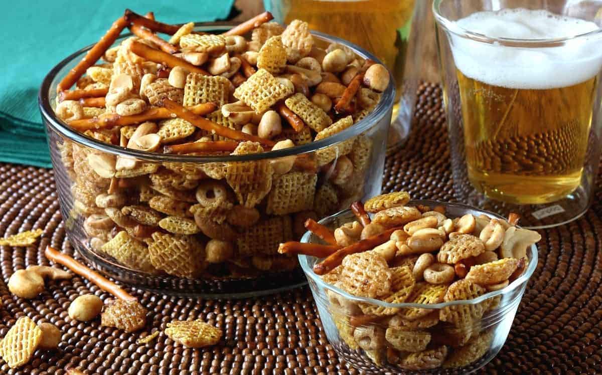 Glass serving bowl and individual bowl filled with snack mix.