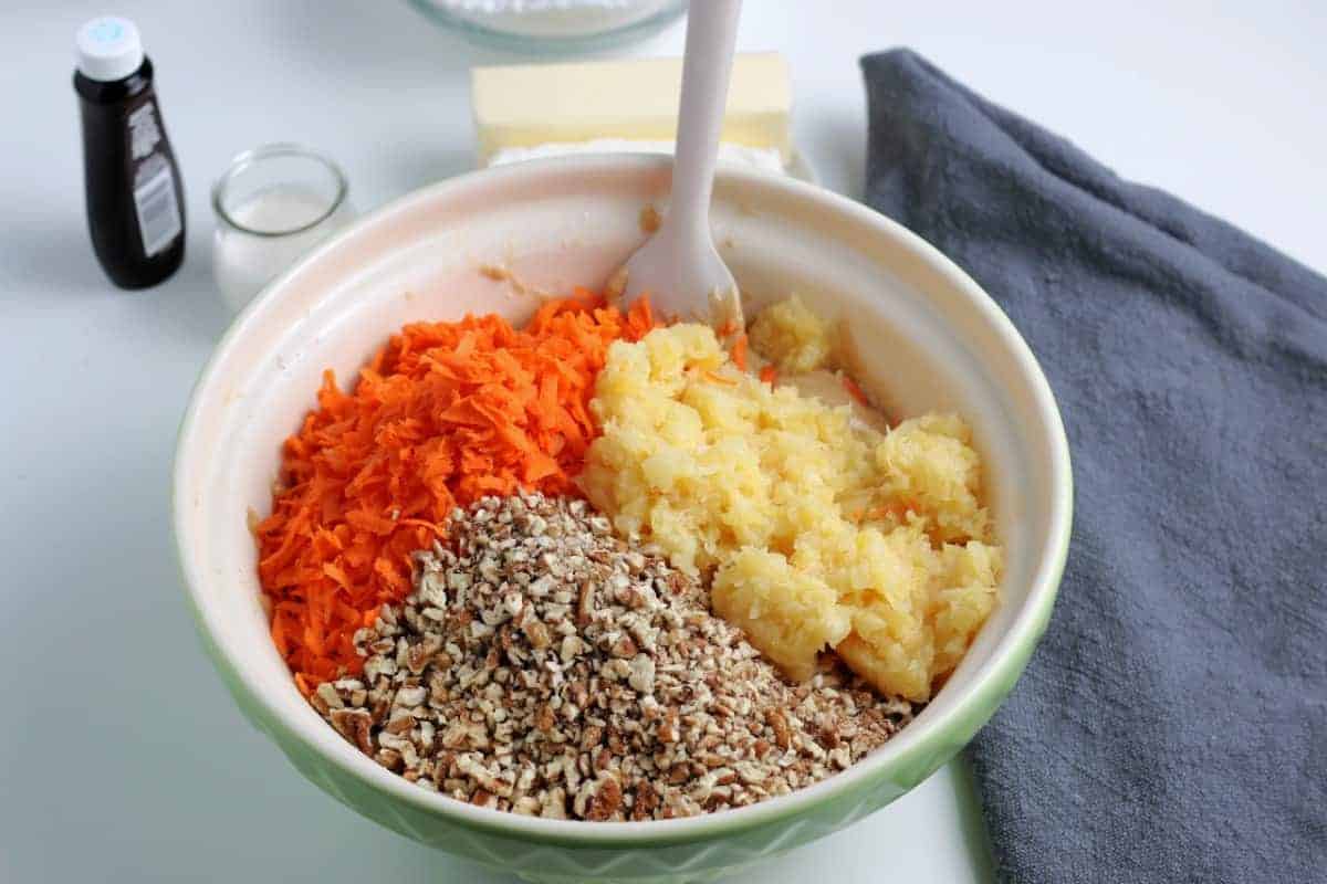 Mixing bowl filled with the shredded carrots, crushed pineapple and chopped pecans.