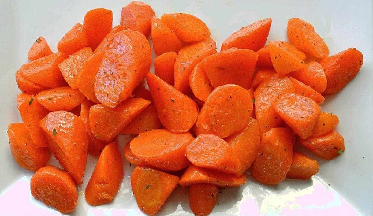 Rolled cut carrots are cooked and in a serving dish.