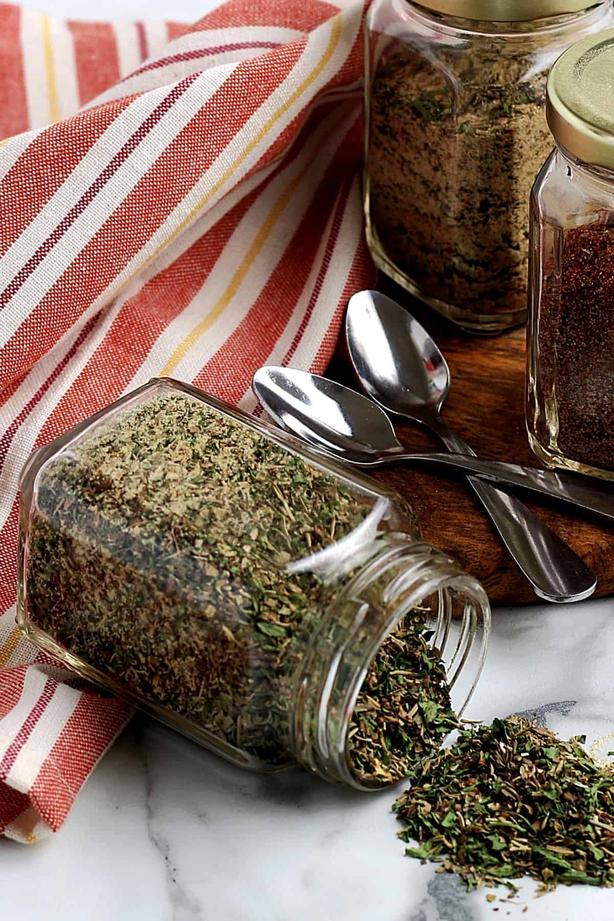 A jar of spilled seasoning in front of two jars of different mixes.