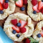 Centered Vegan Cream Cheese Danish & drizzled with icing & berries.
