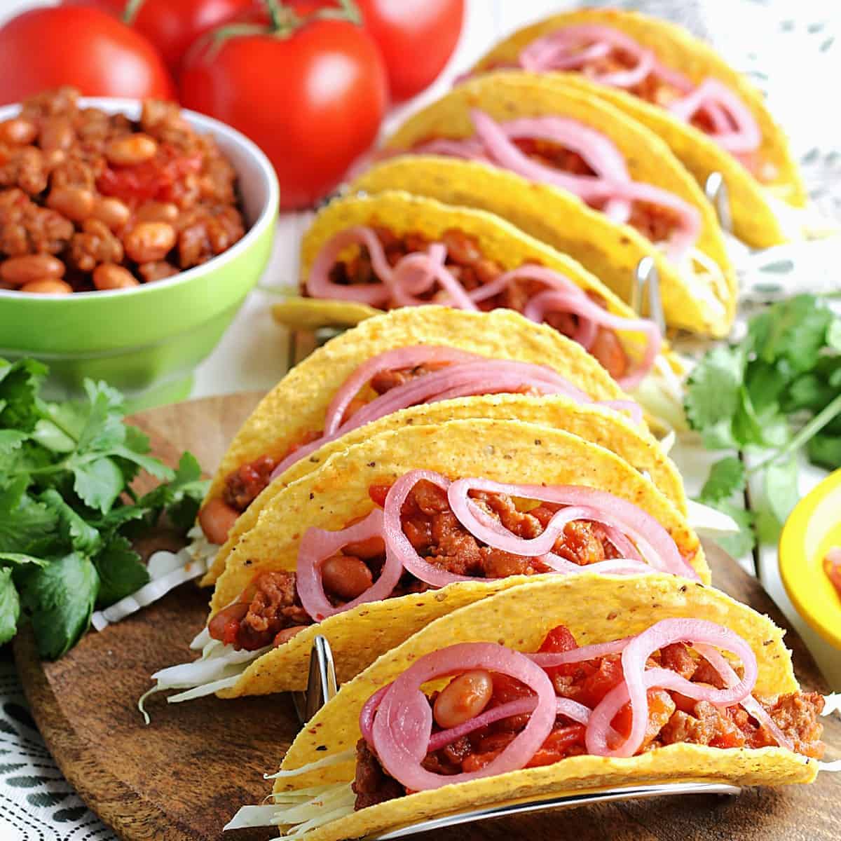 Six tacos lined up and ready to eat.